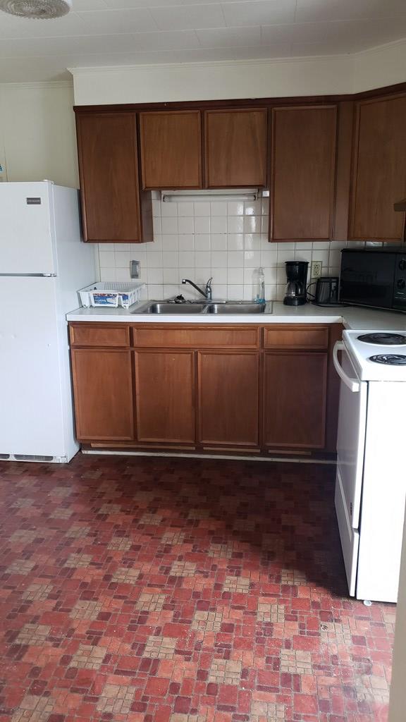 kitchen featuring tasteful backsplash, sink, and white appliances