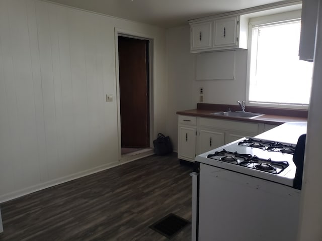 kitchen featuring white cabinetry, white gas stove, dark wood-type flooring, and sink