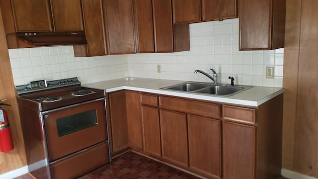 kitchen with electric range, tasteful backsplash, and sink