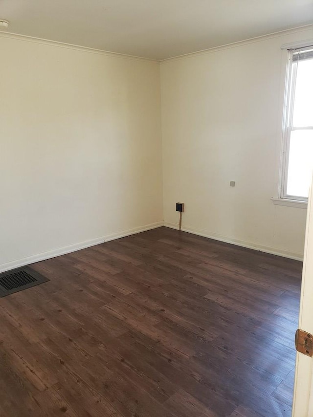 spare room with crown molding and dark hardwood / wood-style floors