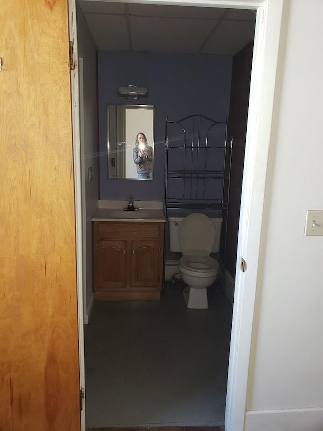 bathroom featuring vanity, toilet, and a paneled ceiling