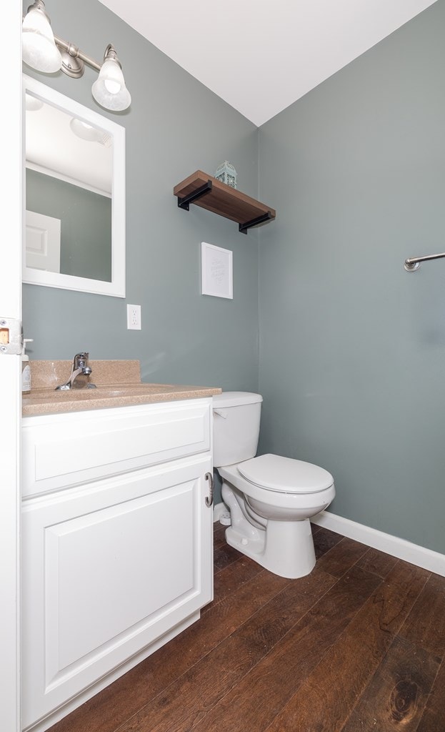 113 W Woodlawn Ave, Elkland, PA 16920 - half bathroom featuring hardwood / wood-style flooring, toilet, vanity, and baseboards