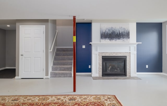 113 W Woodlawn Ave, Elkland, PA 16920 - unfurnished living room featuring stairway, baseboards, finished concrete floors, and a fireplace with flush hearth
