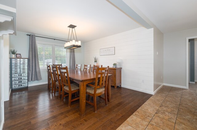 113 W Woodlawn Ave, Elkland, PA 16920 - dining area with a chandelier, baseboards, wood finished floors, and wood walls