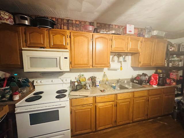 kitchen featuring white appliances, light countertops, and a sink