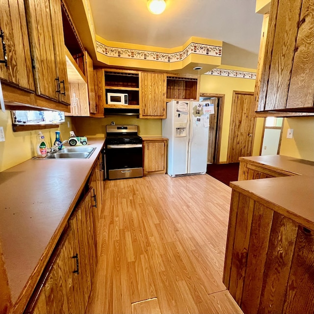 kitchen featuring white appliances, light hardwood / wood-style floors, and sink