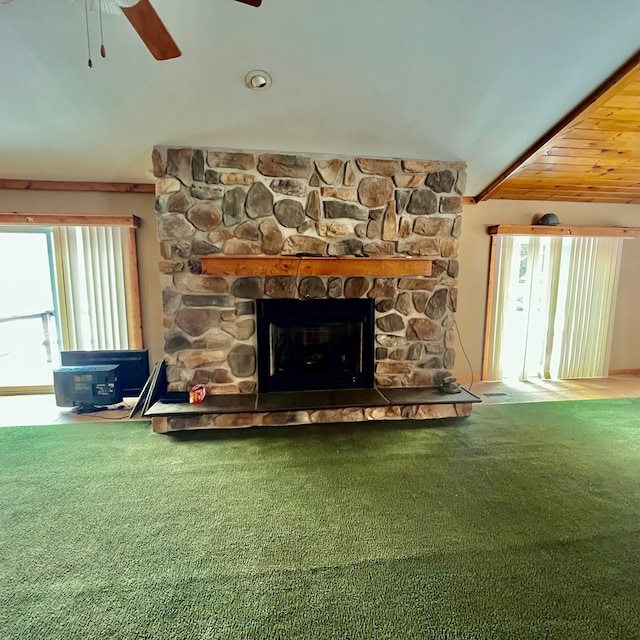 room details featuring carpet, ceiling fan, beamed ceiling, and a fireplace