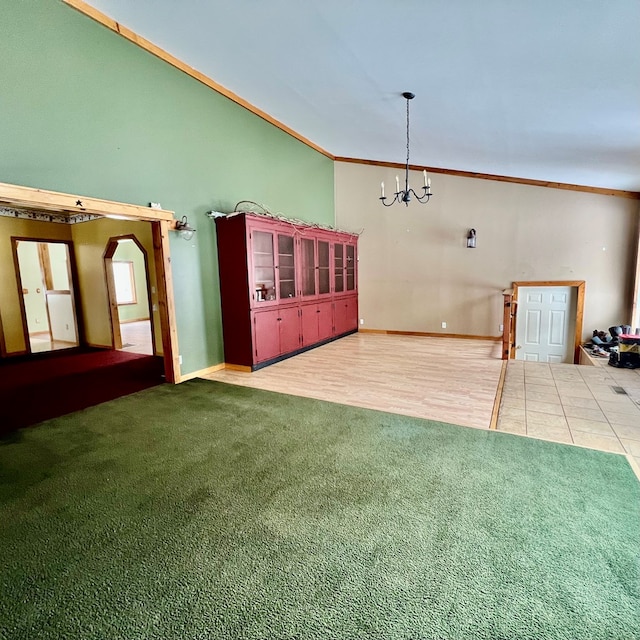 interior space featuring carpet flooring, crown molding, an inviting chandelier, and lofted ceiling