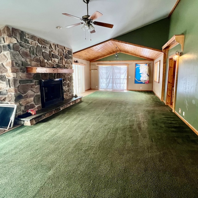 unfurnished living room featuring ceiling fan, a stone fireplace, vaulted ceiling, and carpet