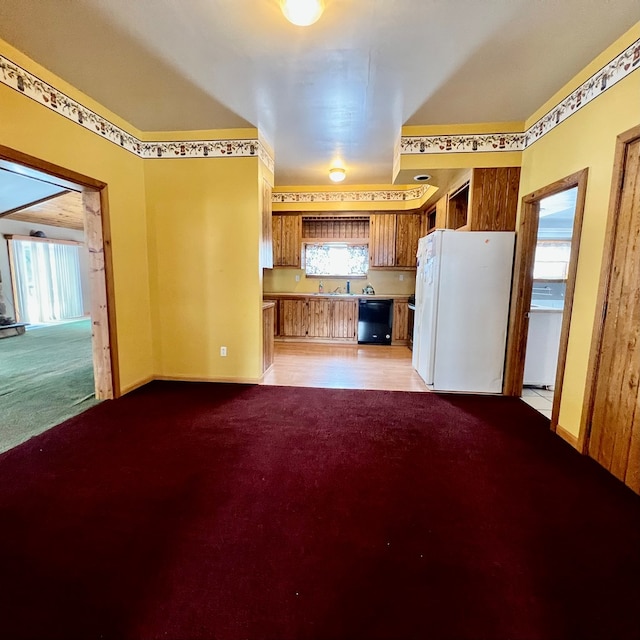 kitchen with white fridge, black dishwasher, and light carpet