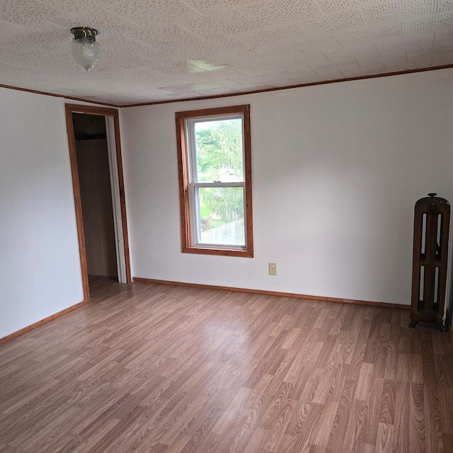 unfurnished room featuring a textured ceiling and light hardwood / wood-style floors