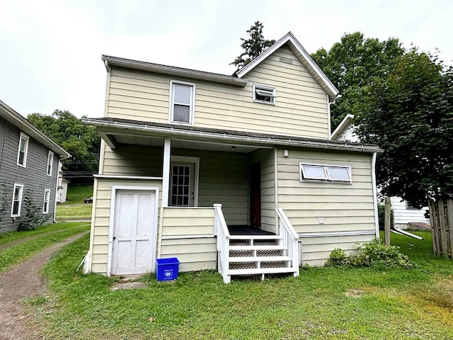 rear view of house featuring a yard