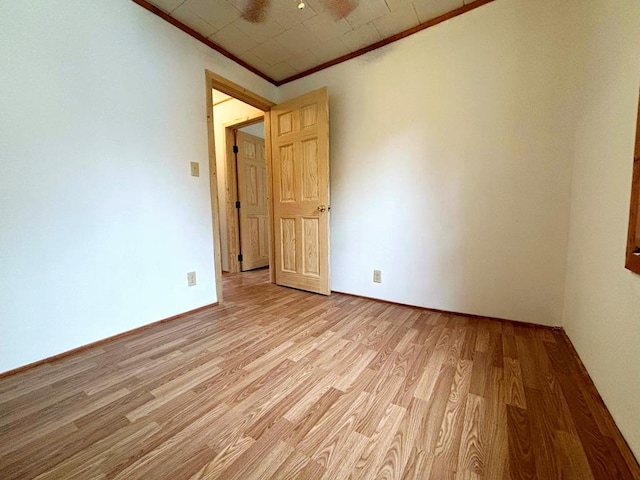 spare room featuring light hardwood / wood-style floors and ornamental molding