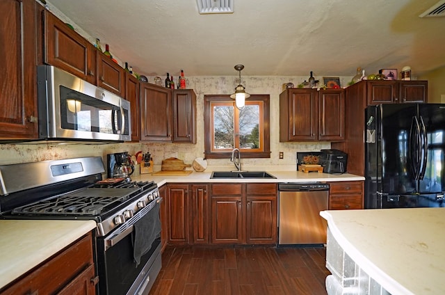 kitchen with sink, hanging light fixtures, dark hardwood / wood-style floors, and appliances with stainless steel finishes