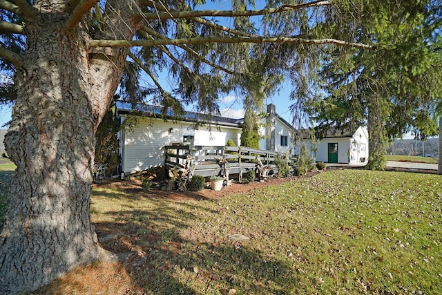 back of property with a lawn and a deck