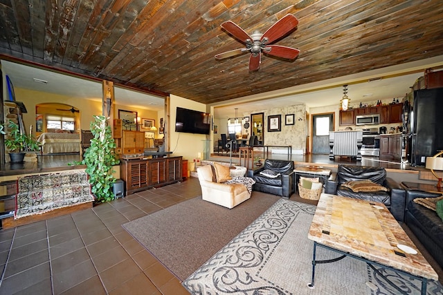 living room with dark tile patterned floors and ceiling fan