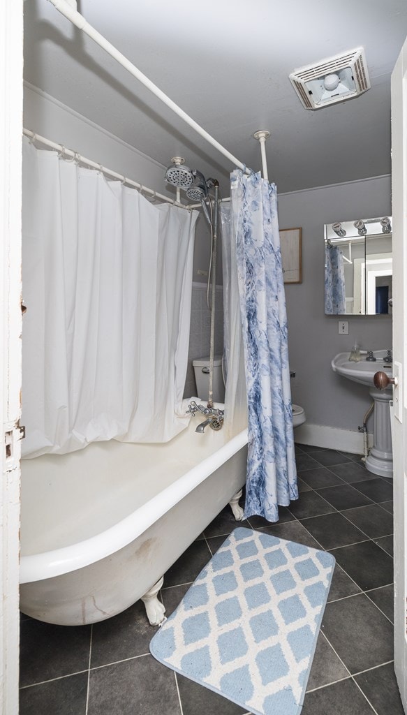 bathroom with tile patterned floors, toilet, and shower / tub combo