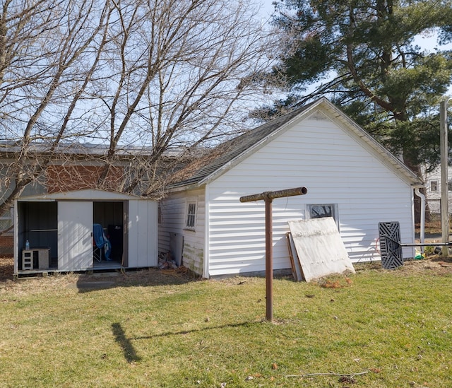 back of house with a lawn and a storage shed