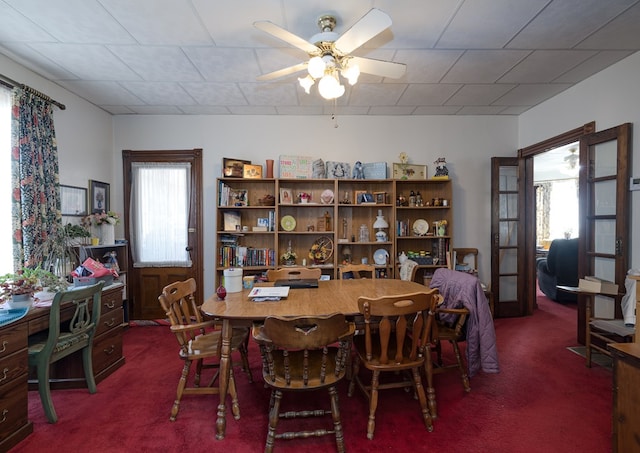 carpeted dining room featuring ceiling fan and a healthy amount of sunlight