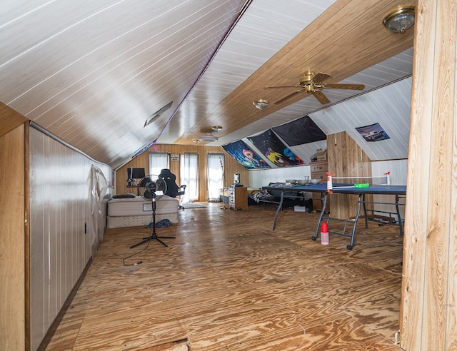 office area featuring wooden walls, ceiling fan, wood-type flooring, and vaulted ceiling