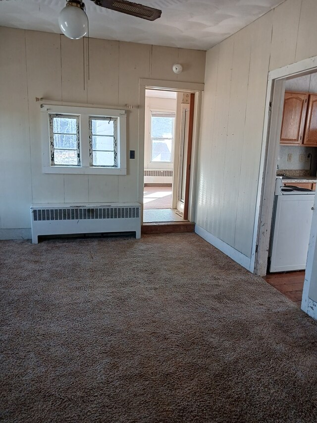 carpeted empty room with radiator heating unit