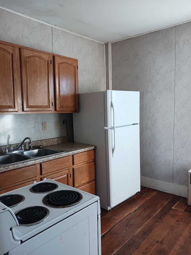 kitchen with white appliances, dark hardwood / wood-style flooring, and sink