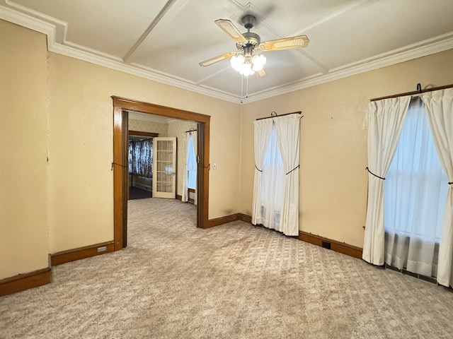 empty room with carpet, ornamental molding, ceiling fan, and baseboards