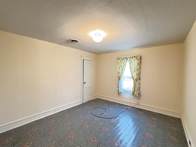 unfurnished room featuring baseboards and visible vents