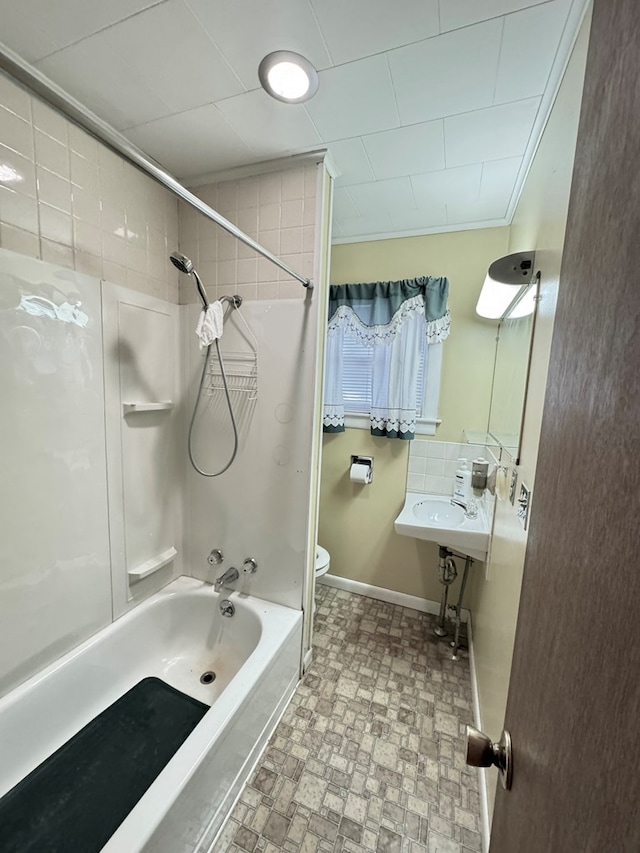 full bathroom featuring toilet, baseboards, tub / shower combination, and a sink