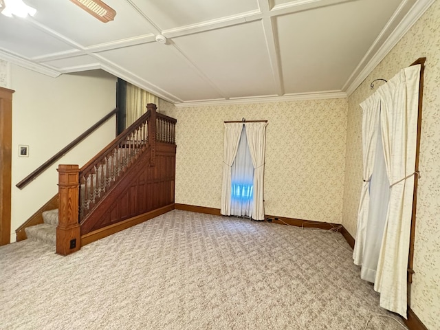 carpeted spare room featuring wallpapered walls, baseboards, and stairway