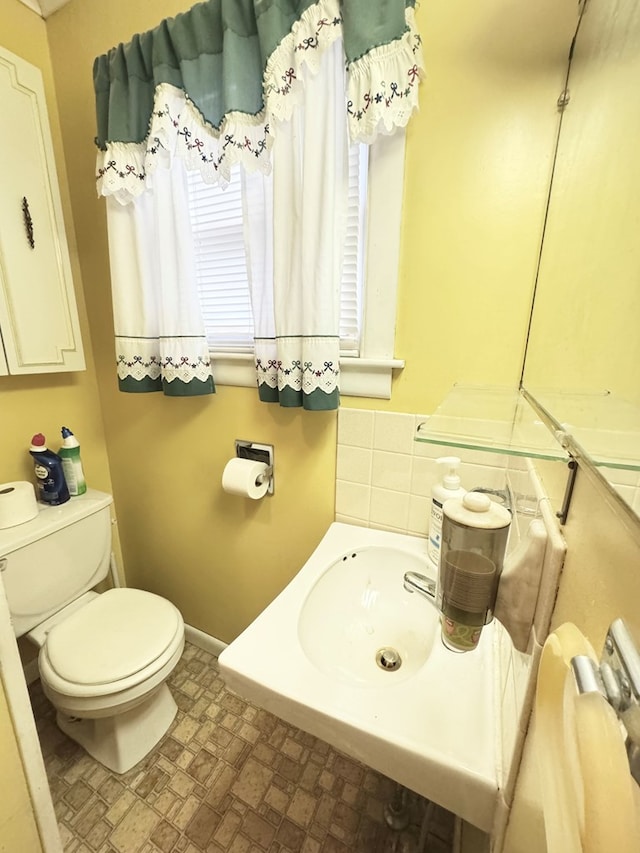 bathroom featuring baseboards and toilet