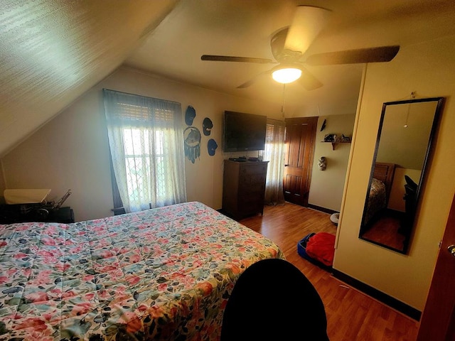 bedroom featuring hardwood / wood-style flooring, vaulted ceiling, and ceiling fan