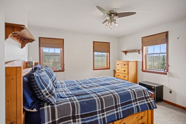 bedroom with a ceiling fan, light colored carpet, and baseboards