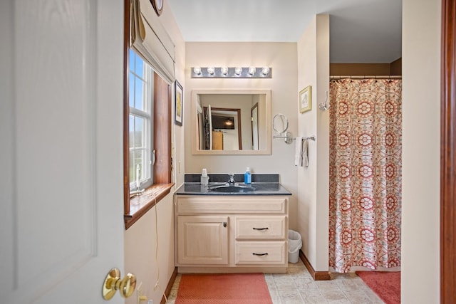 full bath with baseboards, a shower with shower curtain, and vanity