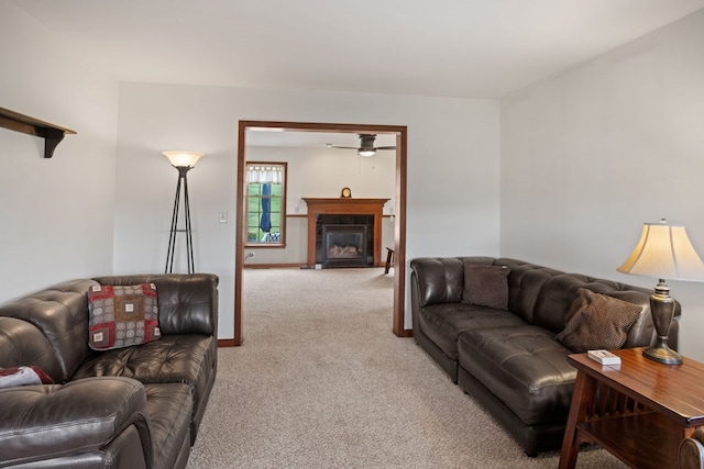 living room with light colored carpet, ceiling fan, and a glass covered fireplace