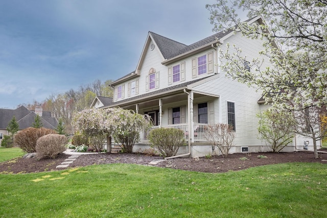 view of front of home with roof with shingles, covered porch, and a front lawn