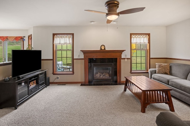 living area with baseboards, a wealth of natural light, carpet floors, and a fireplace