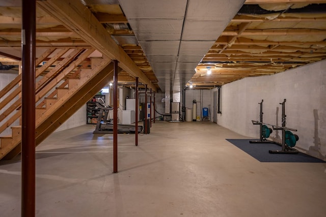 unfinished basement featuring heating unit, water heater, and stairs