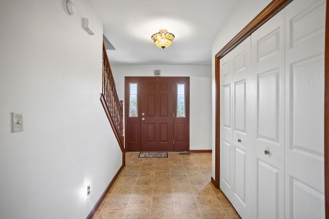 entrance foyer with stairs and baseboards