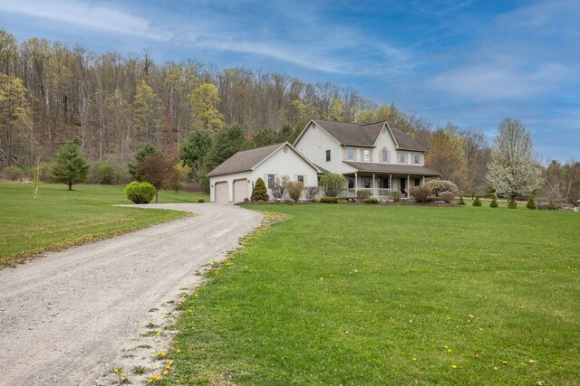 view of front of house featuring driveway, covered porch, a front yard, and a garage