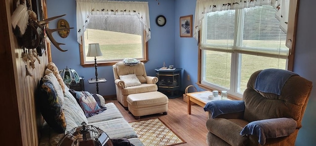 sitting room featuring hardwood / wood-style flooring and a wood stove