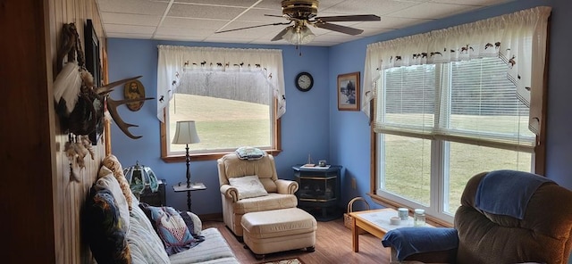 sitting room featuring a wealth of natural light, ceiling fan, hardwood / wood-style floors, and a paneled ceiling