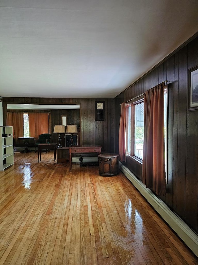 71 Kendrick Rd, Covington, PA 16917 - living area featuring baseboard heating, wood-type flooring, wooden walls, and healthy amount of natural light