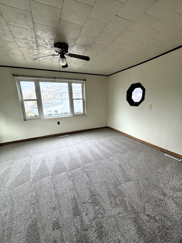 carpeted spare room with ceiling fan