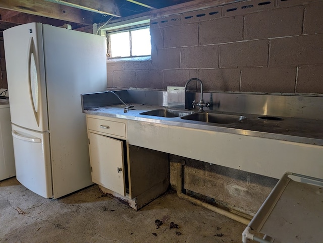 1057 Stony Fork Rd, Wellsboro, PA 16901 - kitchen featuring a sink, light countertops, concrete block wall, freestanding refrigerator, and white cabinetry
