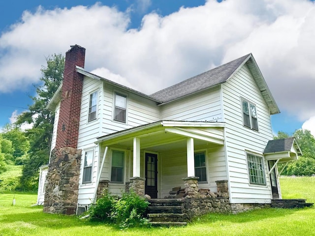 10598 Leetonia Rd, Gaines, PA 16921 - view of front of home with a chimney, covered porch, a front lawn, and roof with shingles