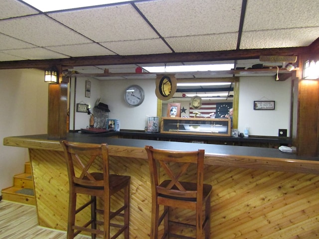 bar featuring hardwood / wood-style floors and a drop ceiling