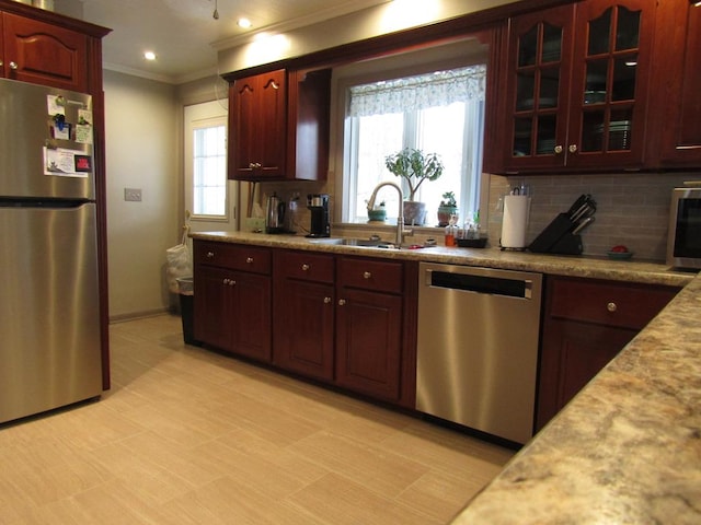 kitchen featuring sink, crown molding, plenty of natural light, and stainless steel appliances