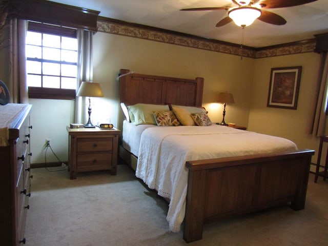 carpeted bedroom with ceiling fan and ornamental molding