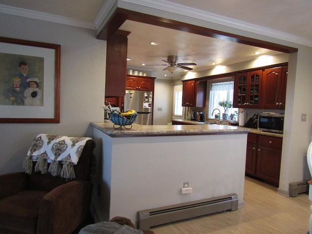 kitchen with baseboard heating, ornamental molding, kitchen peninsula, ceiling fan, and stainless steel appliances